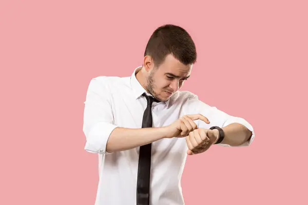 Schöner Geschäftsmann überprüft seine Armbanduhr isoliert auf rosa Hintergrund — Stockfoto