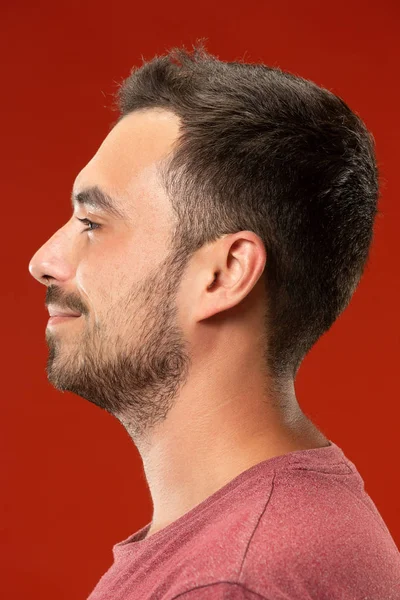 The happy business man standing and smiling against red background. — Stock Photo, Image