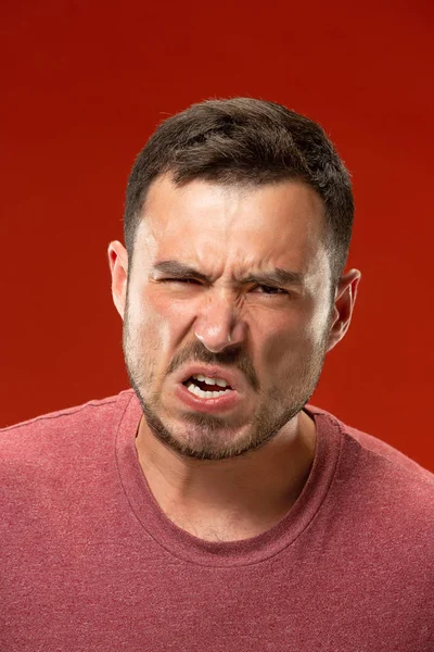 El joven hombre enojado emocional gritando en el fondo rojo del estudio — Foto de Stock