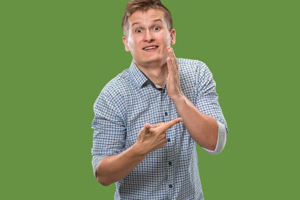 De jonge man die een geheim achter haar hand fluisteren over groene achtergrond — Stockfoto