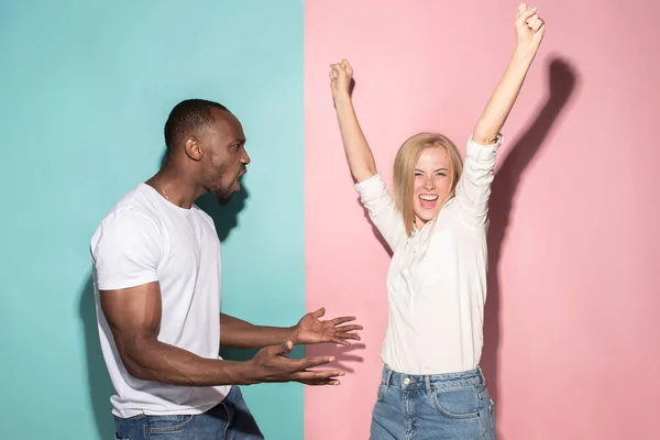 Έχουμε κερδίσει. Κερδίζοντας επιτυχία ευτυχισμένη Αφρο άνδρας και η γυναίκα γιορτάζει είναι ο νικητής. Δυναμική εικόνα των καυκάσιος άνδρες και γυναίκες μοντέλο σε ροζ studio. — Φωτογραφία Αρχείου