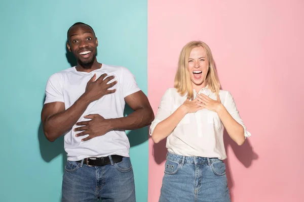 happy afro man and woman. Dynamic image of caucasian female and afro male model on pink studio.