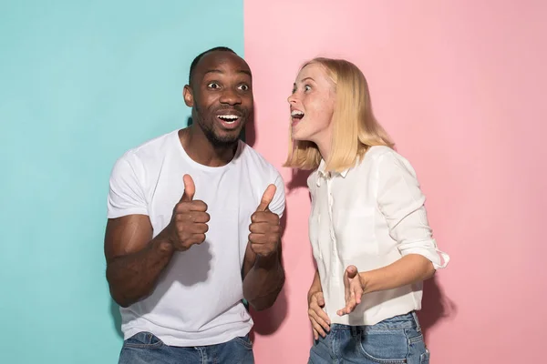 Boldog afro férfi és a nő. Dinamikus kép kaukázusi nő és afro férfi modell, a rózsaszín stúdió. — Stock Fotó