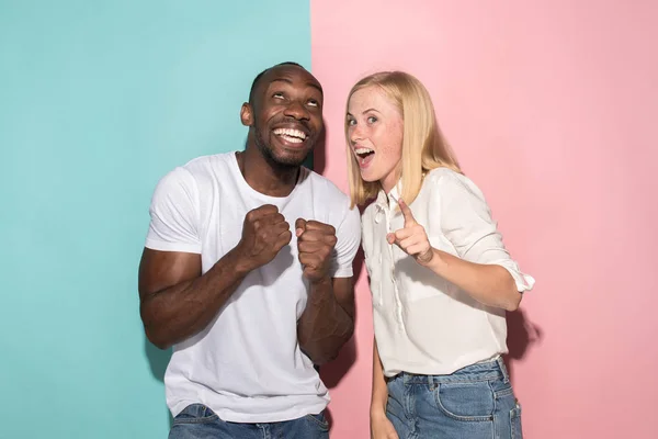 Feliz afro hombre y mujer. Imagen dinámica del modelo caucásico femenino y afro masculino en estudio rosa . —  Fotos de Stock