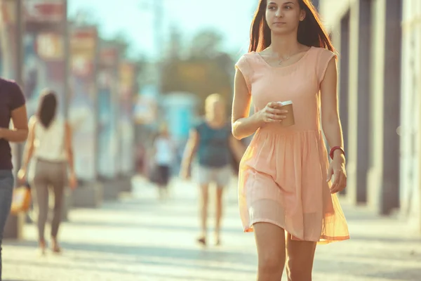 Schöne Frau hält Kaffeetasse aus Papier und genießt den Spaziergang in der Stadt — Stockfoto