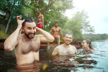 Arkadaş grubu zevk orman parti. Grup güzel mutlu genç erkek ve kızlar birlikte nehirde yüzme. Yaz, parti, macera, gençlik, dostluğunu kavramı