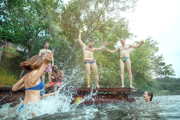 Korzystających ze stron rzeki z przyjaciółmi. Grupa piękny szczęśliwy młodych ludzi nad rzeką razem — Zdjęcie stockowe