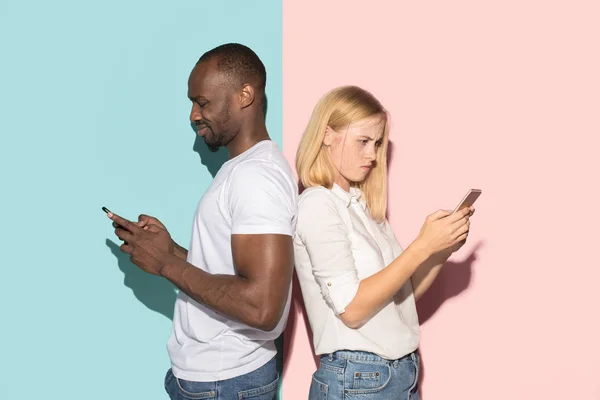 混合赛跑的夫妇的学生拿着手机。白种女孩和她的非洲男友在工作室假扮 . — 图库照片