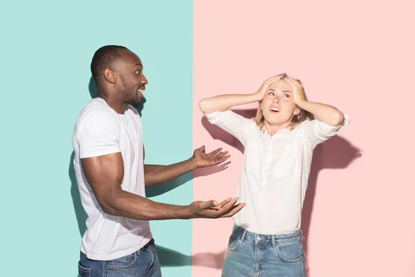 Beau portrait féminin et masculin sur fond studio rose et bleu. Le jeune couple émotionnel — Photo