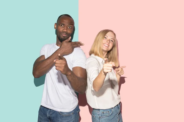 Hermoso retrato femenino y masculino sobre fondo de estudio rosa y azul. La joven pareja emocional —  Fotos de Stock