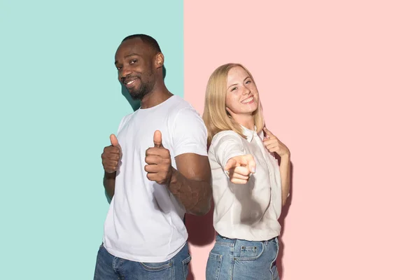 O casal feliz apontar para você e quer que você, metade de comprimento close-up retrato no fundo do estúdio . — Fotografia de Stock