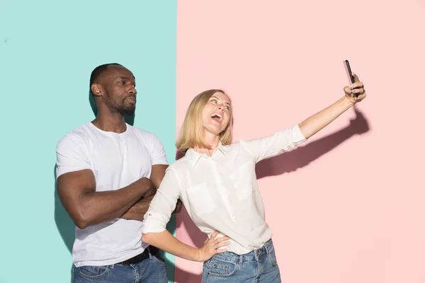 Μικτή έτρεξε ζευγάρι φοιτητών λαμβάνοντας κοινά selfie με το τηλέφωνο. Καυκάσιος κορίτσι και ο φίλος της Αφρικής ποζάρει στο studio . — Φωτογραφία Αρχείου