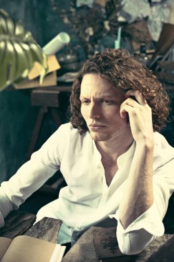 Yazar iş başında. Masada oturan ve bir şey onun eskiz defteri yazma yakışıklı genç yazar