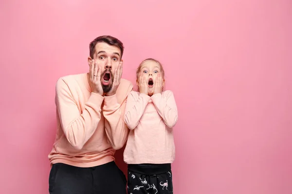 Surprised young family looking at camera on pink — Stock Photo, Image