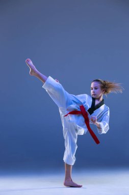 Genç kız eğitim karate mavi zemin üzerine