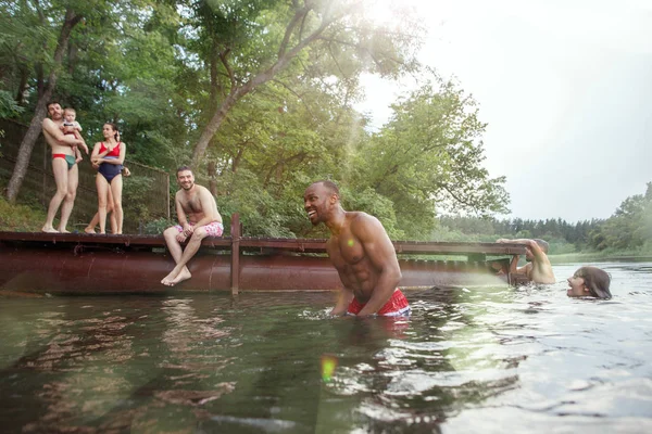 Disfrutando de la fiesta en el río con amigos. Grupo de jóvenes felices y hermosos en el río juntos —  Fotos de Stock