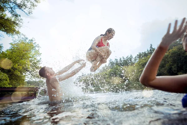 Profiter de la fête de la rivière avec des amis. Groupe de beaux jeunes gens heureux à la rivière ensemble — Photo