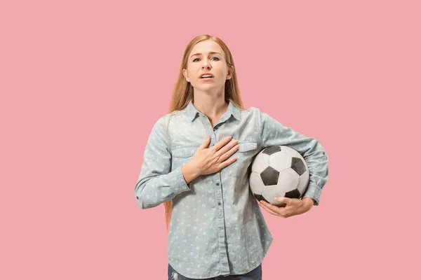 Fanoušek sportu žena hráč drží fotbalový míč izolovaných na růžovém pozadí — Stock fotografie