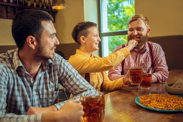 Lidé, volný čas, přátelství a komunikační koncept - happy přátelé pití piva, mluví a cinkání brýle na bar či hospodu — Stock fotografie