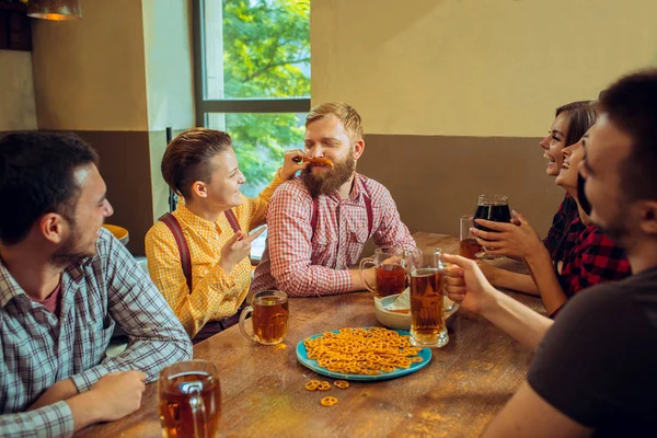 Lidé, volný čas, přátelství a komunikační koncept - happy přátelé pití piva, mluví a cinkání brýle na bar či hospodu — Stock fotografie