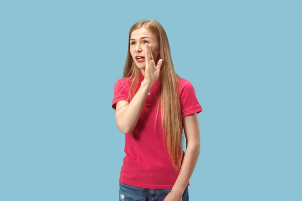 De jonge vrouw die een geheim achter haar hand fluisteren over blauwe achtergrond — Stockfoto