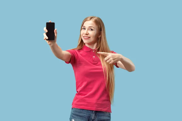 Portrét jistý neformální dívka ukazuje prázdnou obrazovku mobilního telefonu izolované nad modrým pozadím — Stock fotografie