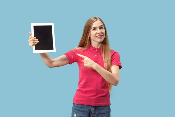 Portrét jistý neformální dívka zobrazení prázdné obrazovky notebooku nad modrým pozadím, samostatný — Stock fotografie