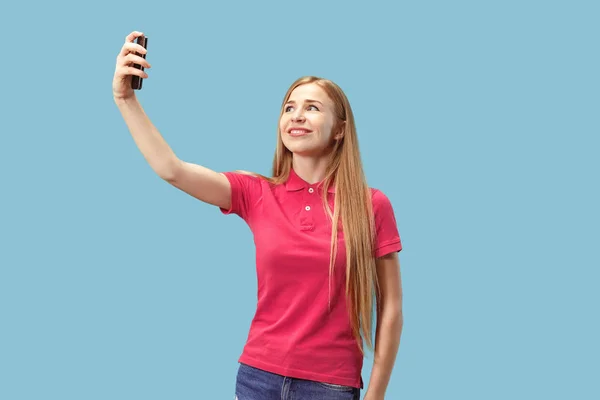 Portrét usmívající se příležitostné šťast zobrazuje prázdná obrazovka mobilní telefon nad modrým pozadím, samostatný — Stock fotografie
