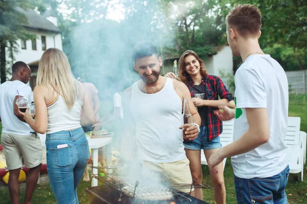 Grupo de amigos a fazer churrasco no quintal. conceito sobre bom humor e positivo com os amigos — Fotografia de Stock