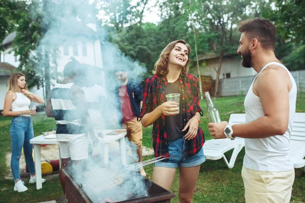 Grupo de amigos haciendo barbacoa en el patio trasero. concepto sobre el buen humor y positivo con los amigos — Foto de Stock