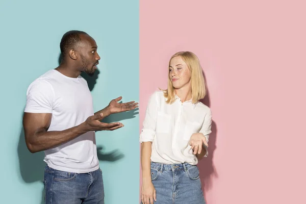 Beau portrait féminin et masculin sur fond studio rose et bleu. Le jeune couple émotionnel — Photo