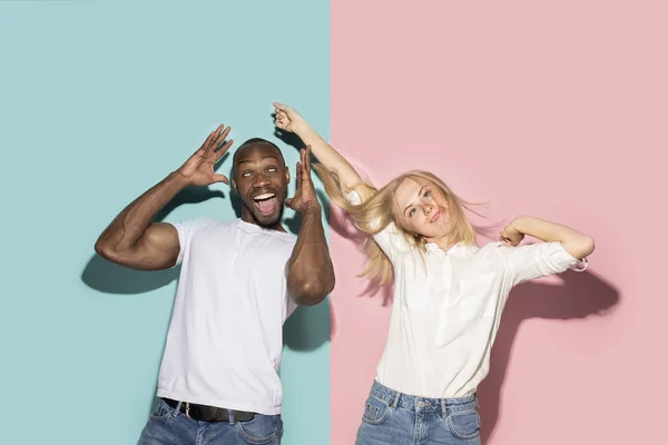 La pareja de ojos entrecerrados con expresión extraña en estudio azul y rosa —  Fotos de Stock