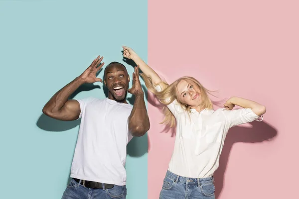 O casal de olhos cintilantes com expressão estranha no estúdio azul e rosa — Fotografia de Stock