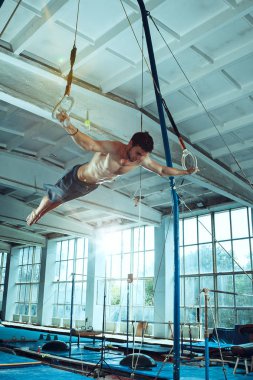 Zor gerçekleştirme sporcu egzersiz, spor jimnastik kapalı. Egzersiz, jimnastikçi, sporcu, sağlık, jimnastik, eğitim, beyaz model uyum atlet kavramı