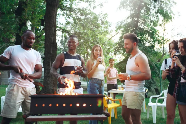 Grupo de amigos a fazer churrasco no quintal. conceito sobre bom humor e positivo com os amigos — Fotografia de Stock