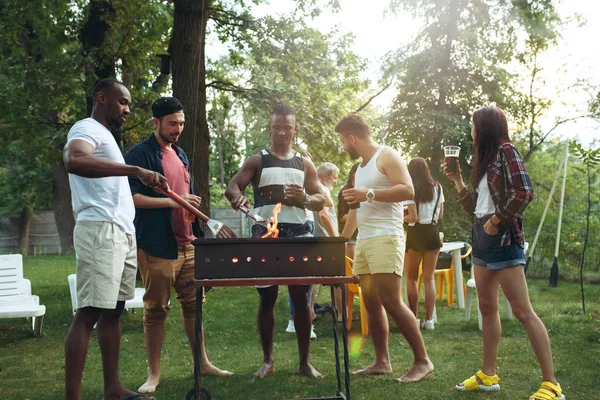 Grupo de amigos haciendo barbacoa en el patio trasero. concepto sobre el buen humor y positivo con los amigos — Foto de Stock