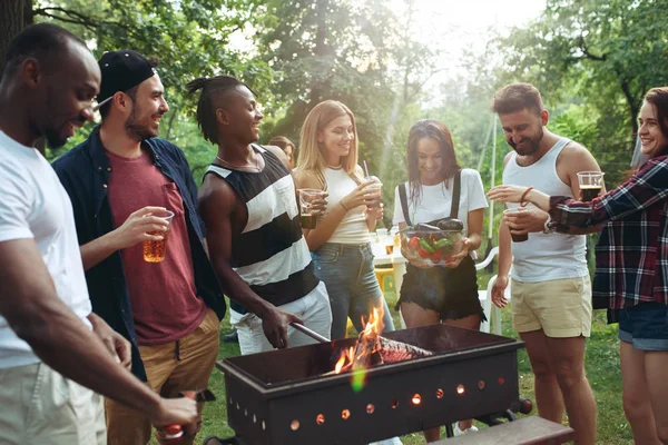 Grupo de amigos haciendo barbacoa en el patio trasero. concepto sobre el buen humor y positivo con los amigos — Foto de Stock