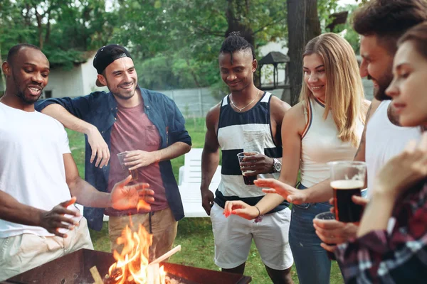 Grupo de amigos haciendo barbacoa en el patio trasero. concepto sobre el buen humor y positivo con los amigos — Foto de Stock