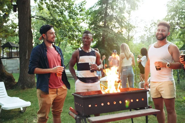 Группа друзей устраивает барбекю на заднем дворе. концепция о хорошем и позитивном настроении с друзьями — стоковое фото