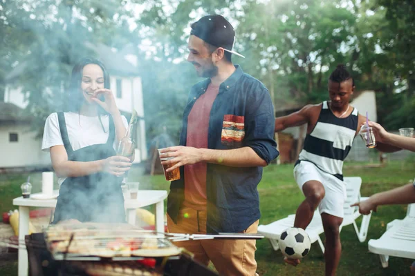 Un gruppo di amici che fanno barbecue in giardino. concetto di buon umore e positivo con gli amici — Foto Stock