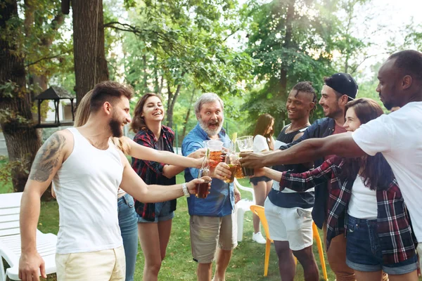Grupo de amigos haciendo barbacoa en el patio trasero. concepto sobre el buen humor y positivo con los amigos — Foto de Stock
