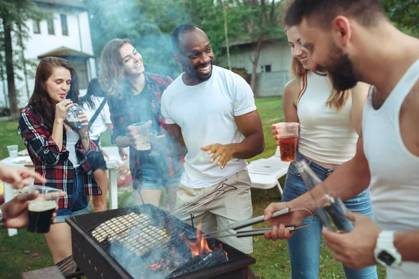 Группа друзей устраивает барбекю на заднем дворе. концепция о хорошем и позитивном настроении с друзьями — стоковое фото