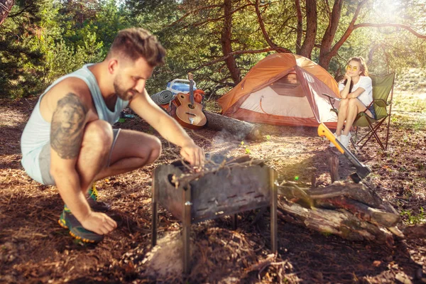 Fiesta, camping de hombres y mujeres grupo en el bosque. Se relajan —  Fotos de Stock