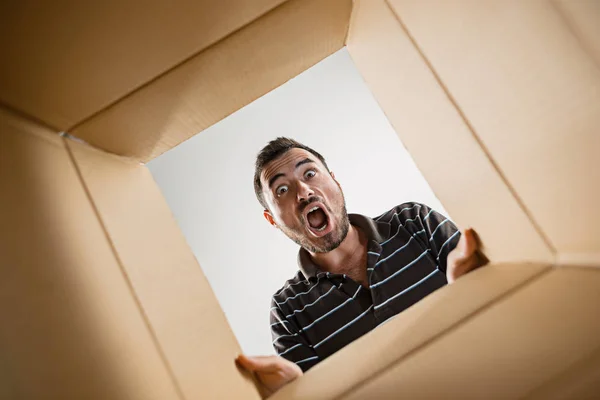 Homme déballer et ouvrir la boîte en carton et regarder à l'intérieur — Photo