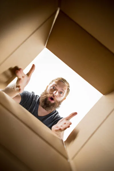 Hombre desembalaje y apertura caja de cartón y mirando dentro —  Fotos de Stock