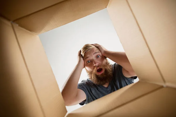 Ο άνθρωπος αποσυσκευασία και ανοίγοντας το χάρτινο κουτί και ψάχνει μέσα — Φωτογραφία Αρχείου