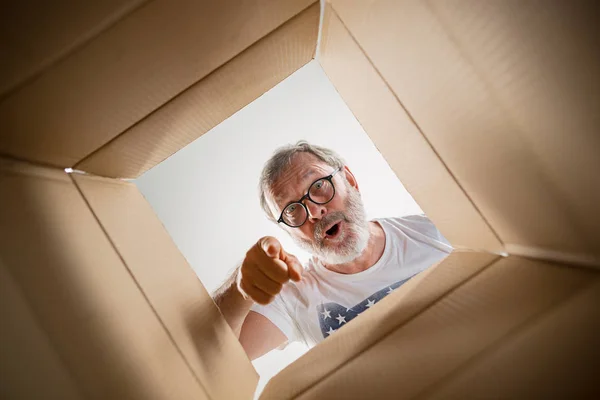 Homme déballer et ouvrir la boîte en carton et regarder à l'intérieur — Photo