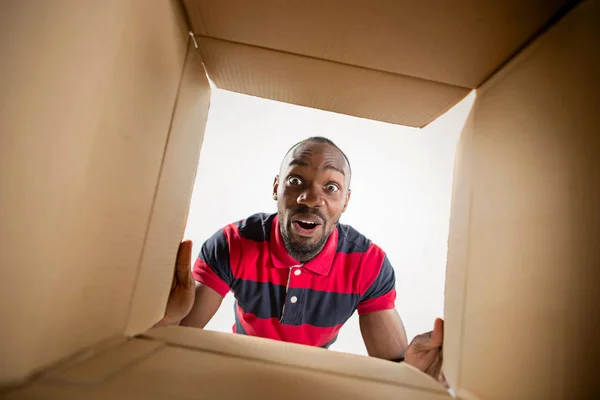 Man unpacking and opening carton box and looking inside — Stock Photo, Image