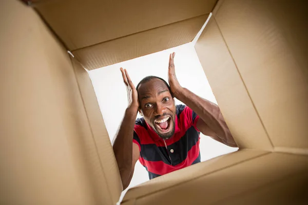 Man unpacking and opening carton box and looking inside — Stock Photo, Image