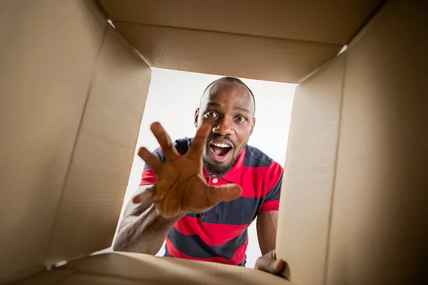 Man unpacking and opening carton box and looking inside — Stock Photo, Image